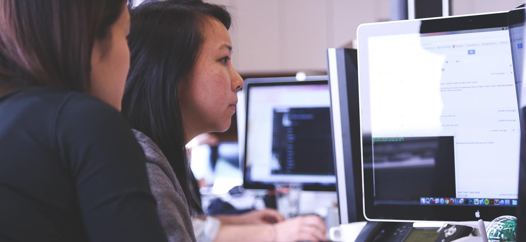 Une femme regardant une autre femme travailler.